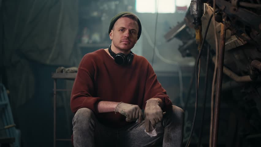 The Art of Maintenance: A Skilled Mechanic's Work Ethic in Action. Tired working mechanic takes off gloves after a hard day