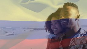 Animation of flag of colombia over african american couple at beach. Vacation and patriotism concept, digitally generated video.