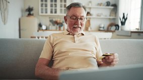 Elderly mature man at home online transaction buying hold credit card successful payment buy on internet. One man senior with laptop computer making online purchase shopping buy stuff hold credit card - Powered by Shutterstock - Get 15% off with code: PIKWIZARD15