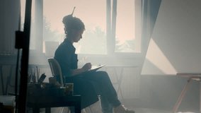 A talented girl draws a sketch of a picture on paper with a pencil. Creates contemporary art in a creative workshop. Portrait of a female artist. Paints on parchment. Red hair, dreadlocks - Powered by Shutterstock - Get 15% off with code: PIKWIZARD15