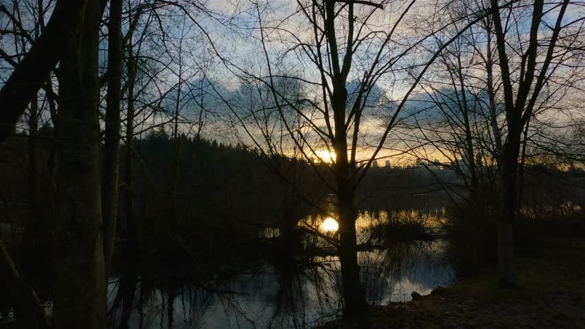 Trail by Peaceful Lake in the modern city, Deer Lake Park. Burnaby, Vancouver, BC, Canada. Colorful Winter Sunset Sky. Slow Motion Cinematic Pan.