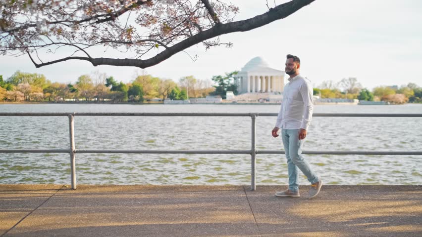 Man walking along side a walkway created on the other side of the Thomas jefferson Memorial during the cherry blossom festival and tidal basin and national mall
