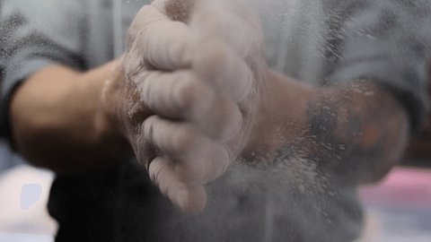 Chef hands clapping hands with flour in super slow motion. Man cooking pastry. Baking dust and particles flying in air. Concept of cookery and bread baking. Vídeo Stock