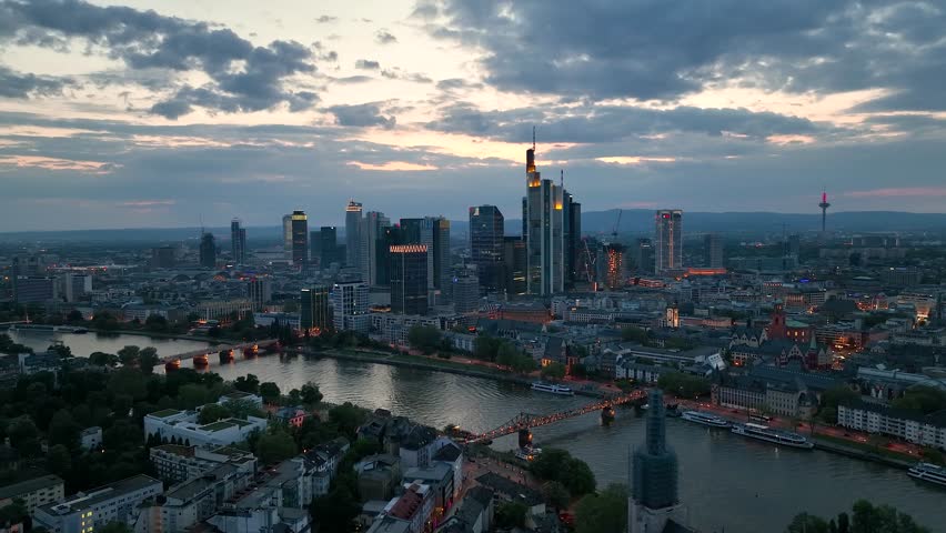 Dolly Flight through Frankfurt am Main, Germany. Skyline. New Skyscrapers. Urban Canyon in Sunset or Sunrise Light. Aerial Pedestal in Establishing Night Drone Shot. Glowing street lights