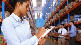 Animation of network of digital icons over biracial female volunteer taking notes at warehouse. Global networking and logistics business technology concept - Powered by Shutterstock - Get 15% off with code: PIKWIZARD15