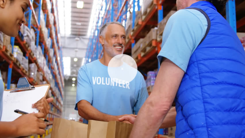 Animation of network of digital icons over two caucasian male volunteers shaking hands at warehouse. Donation and volunteering concept - Powered by Shutterstock - Get 15% off with code: PIKWIZARD15