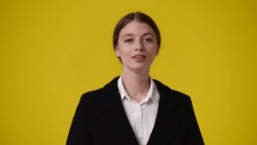 4k video of girl with cunning facial expression on yellow background.