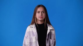 4k video of one girl with crossed hands on blue background.