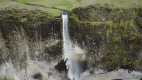Aerial flyover view of waterfall flowing over cliff  Kirkjubaejarklaustur, Iceland