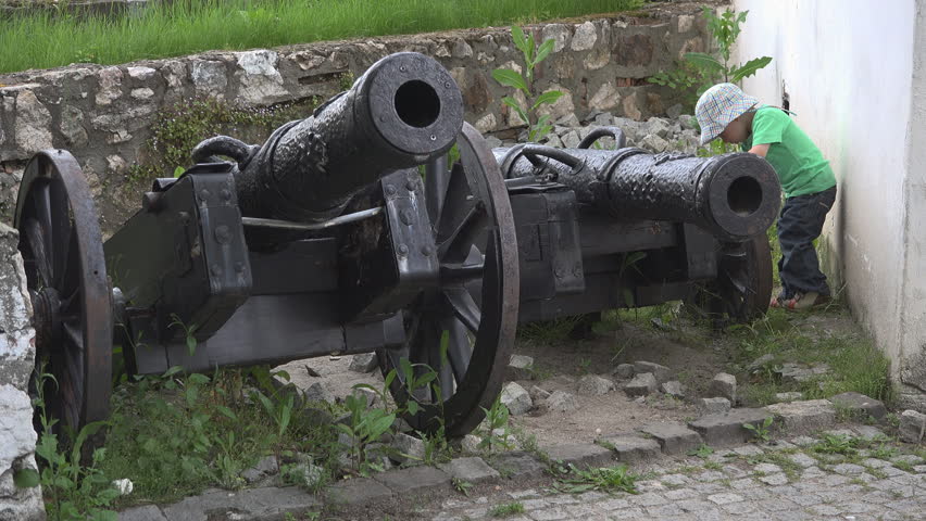 Little boy checking the old historical cannons