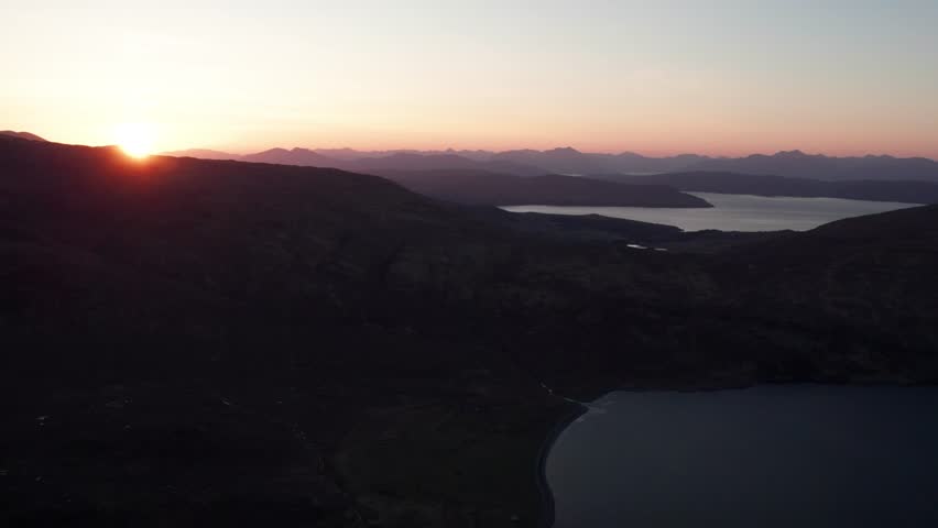 Colorful sunset over Isle of Skye in Scotland at a clear evening. Drone panning