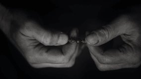 Man's hand holds a wooden rosary with a christian cross. Fingers run over the beads of the rosary during prayer - Powered by Shutterstock - Get 15% off with code: PIKWIZARD15