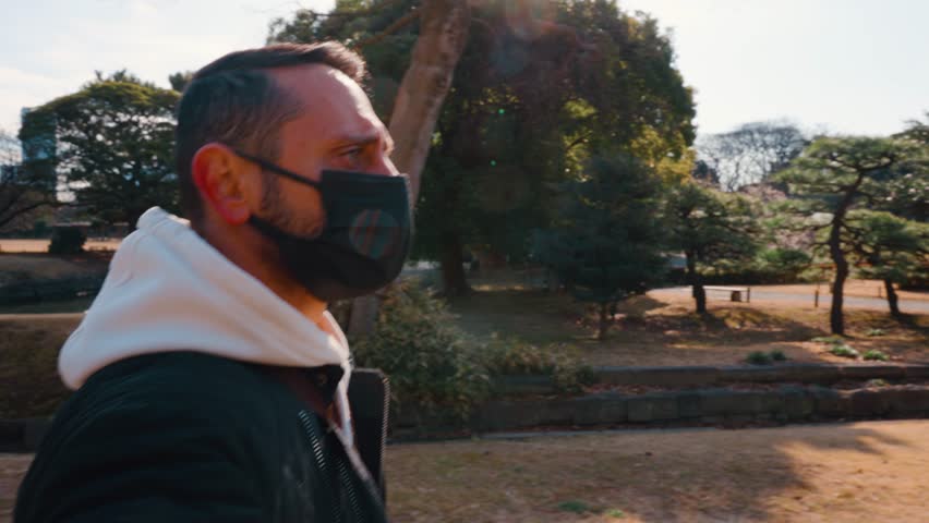 A tourist man walking around Hamarikyu Gardens, which is a natural park area in Shiodome District in Tokyo, Japan