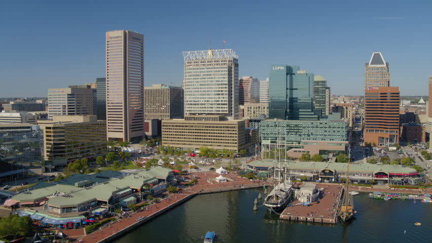 Aerial Panning Shot Of Boats At River While City In Background - Baltimore, Maryland