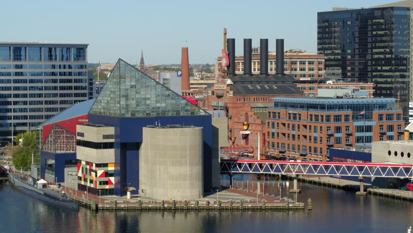 Aerial Shot Of Buildings By Harbor In City, Drone Flying Over River - Baltimore, Maryland