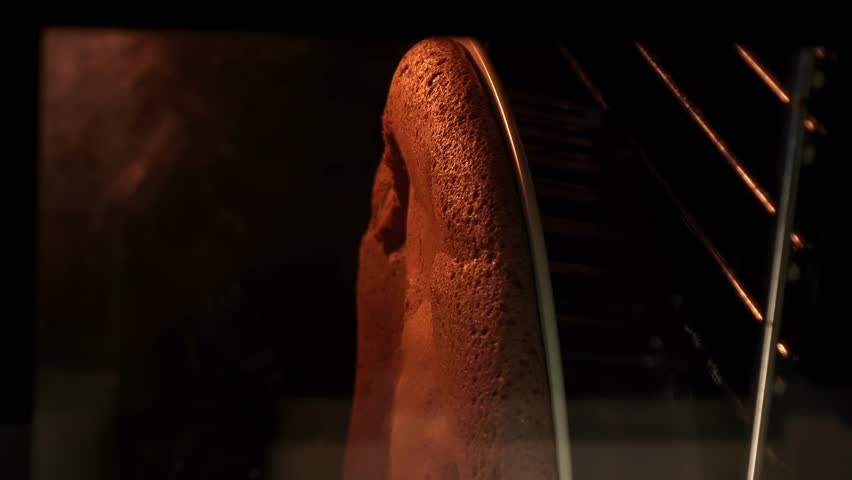 Baking cake in heart shape. Vertical video. Woman hands taking from oven baked chocolate cake. Pie baked in oven. Process of cooking sweet pastry at home
