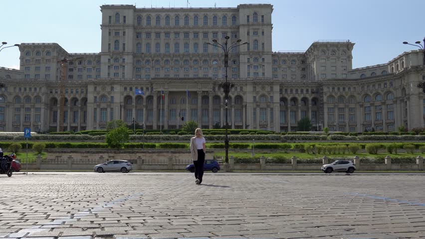 Stunning Lady Strolling Towards the Camera with Palace of the Parliament in the Background, Admiring the View, Tourist Destination, Bucharest, Romania-.mp4