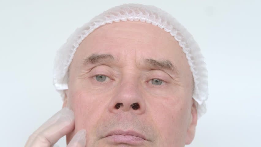 Mature male face, man 60-65 years old years old, doctor, beautician, cosmetologist examines wrinkles, skin, age-related changes concept, aesthetic injection cosmetology, care anti-aging procedures | Shutterstock HD Video #1103577335