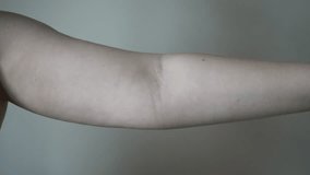 Light-skinned young woman with drooping arms. Sad bad body shape girl. fat on the arms, not inflated biceps, sagging skin. 4k video. Fat, fat arms with excess weight.