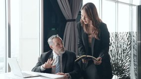 Asian woman secretary working on digital tablet and discussion business project with senior executive CEO at modern office room. Corporate business people partnership and teamwork meeting concept. - Powered by Shutterstock - Get 15% off with code: PIKWIZARD15