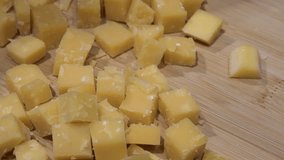 Old Riped Cheese on Wooden Plate Cut in Small Cubes Close-up Slow Motion