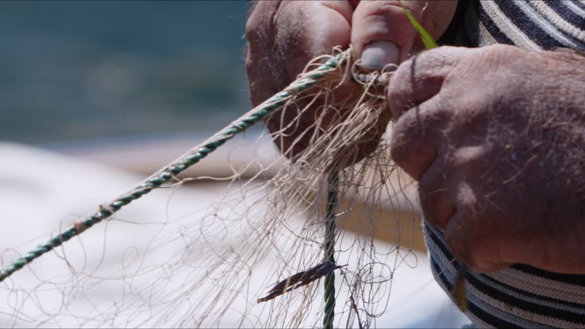 Fisherman is Repairing Fishnets on Fishing Boat in Dock  Video Royalty-Free Stock Footage #1103582929