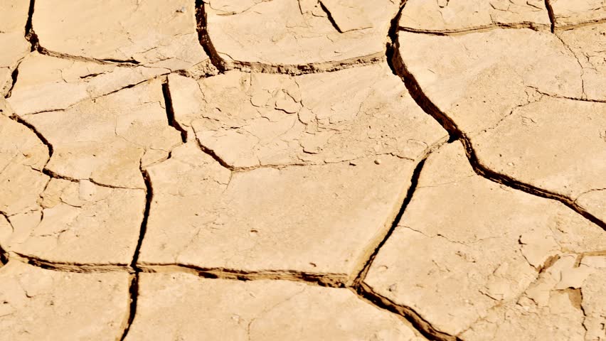 Close-up shot of the cracked surface of a dry lake during a drought. Royalty-Free Stock Footage #1103592381