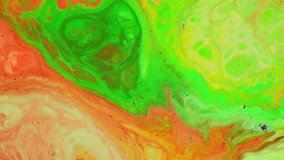 Abstract green orange background footage. Liquid paint mixing backdrop with splash and swirl. Fluid Art painting video