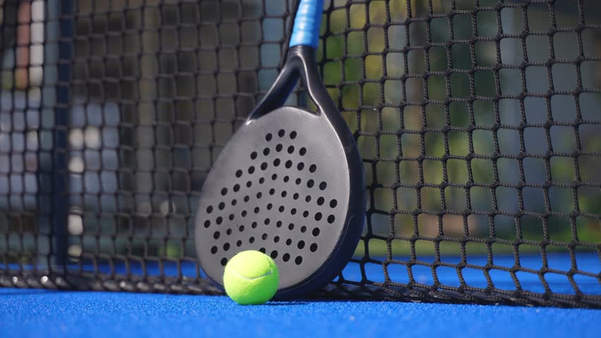 Closeup of a padel player picking up the racket and the ball by the net of the court and starting playing. Royalty-Free Stock Footage #1103600845