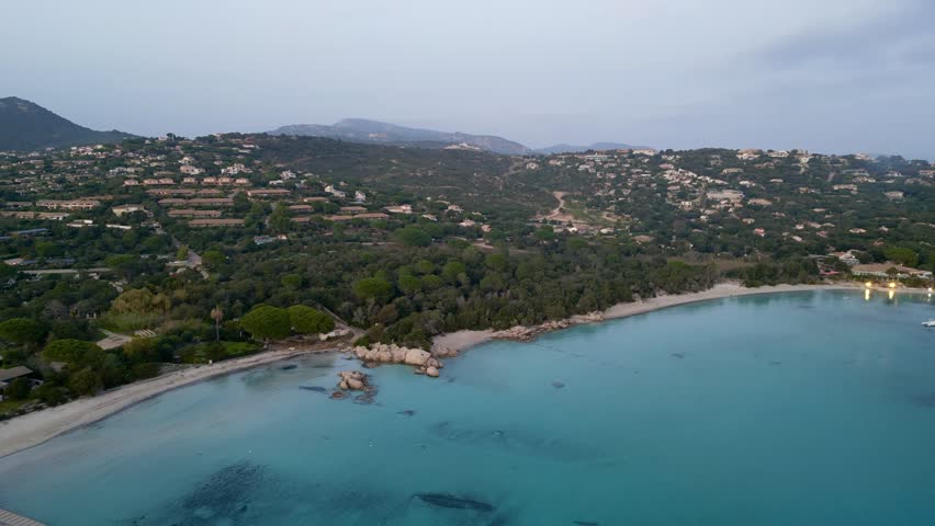 Mesmerizing Aerial Drone Footage of Santa Giulia Beach, Porto-Vecchio, Corsica - An Exquisite Sunset Panorama Amidst Clear Blue Waters and Verdant Scenery