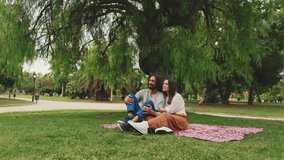Couple talking while sitting on blanket at picnic in the park - Powered by Shutterstock - Get 15% off with code: PIKWIZARD15