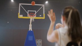 Basketball training game, young woman player successfully throws a basketball into the basket, back view. - Powered by Shutterstock - Get 15% off with code: PIKWIZARD15