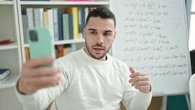 Young hispanic man teacher teaching maths having online lesson at library university