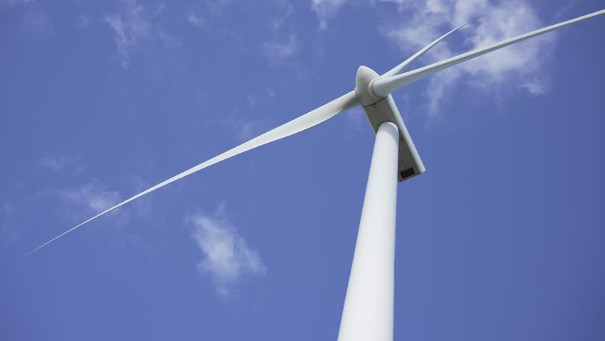 Video of a wind turbine seen from below as its blades move in the wind.