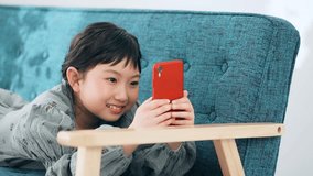Asian little girl using a smart phone.