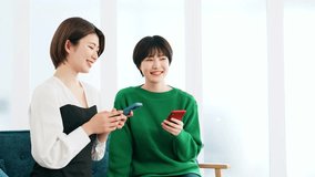 Young casual asian women group looking at smartphone together.