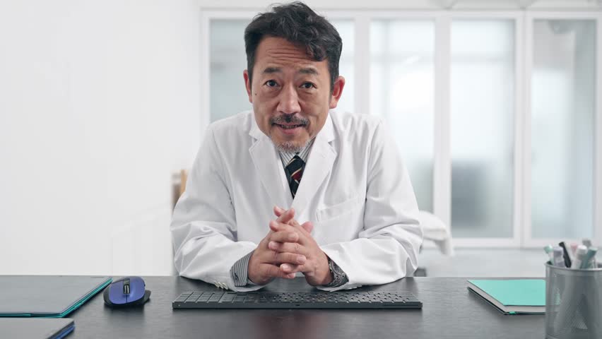 Middle aged Asian doctor talking with video call. Royalty-Free Stock Footage #1103611697