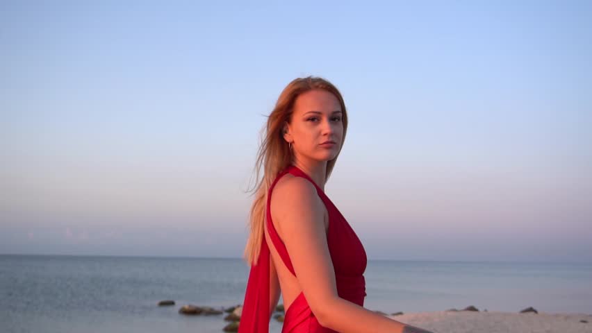Slow Motion Pretty blond woman in the red dress at the beach