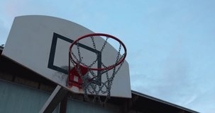 Basketball flying into the basketball hoop. Footage of a ball flying into the basket. Slow motion video from below the basket with the ball flying in. Goal