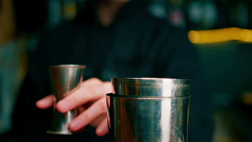 professional bartender creating a cocktail drink Experienced bartender pours an alcoholic drink in shaker - Powered by Shutterstock - Get 15% off with code: PIKWIZARD15