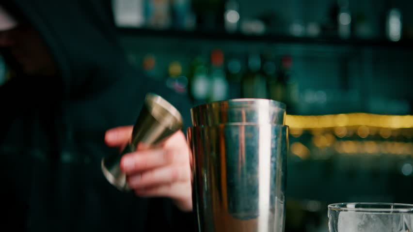 A professional bartender pours alcohol into a measuring cup The process of making cocktails in a club in bar close-up - Powered by Shutterstock - Get 15% off with code: PIKWIZARD15