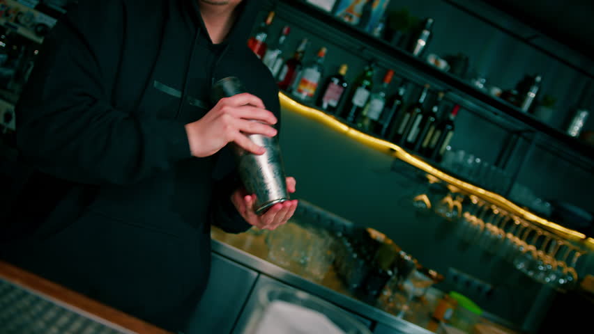 The process of making a cocktail in a bar A bartender mixes the ingredients of an alcoholic cocktail by shaking shaker Royalty-Free Stock Footage #1103622851