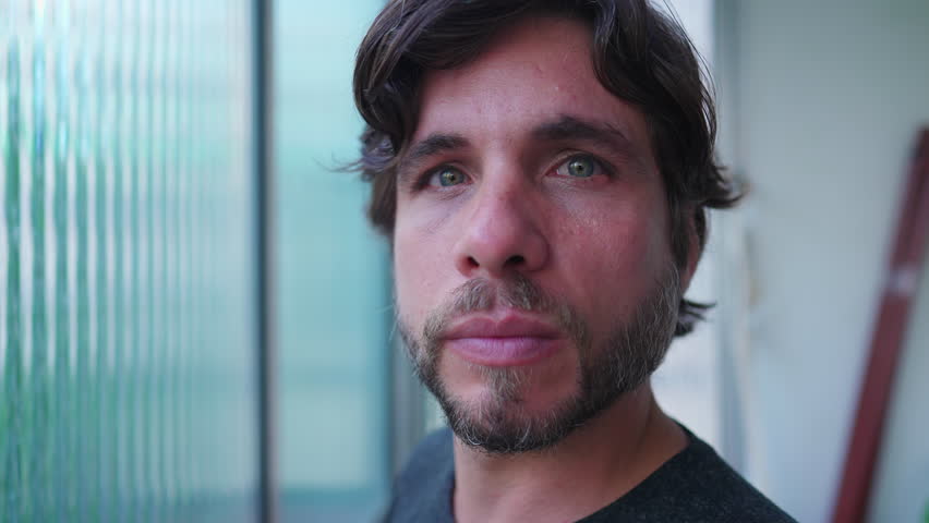 Portrait of a man in 30s looking at camera closeup face with blank expression