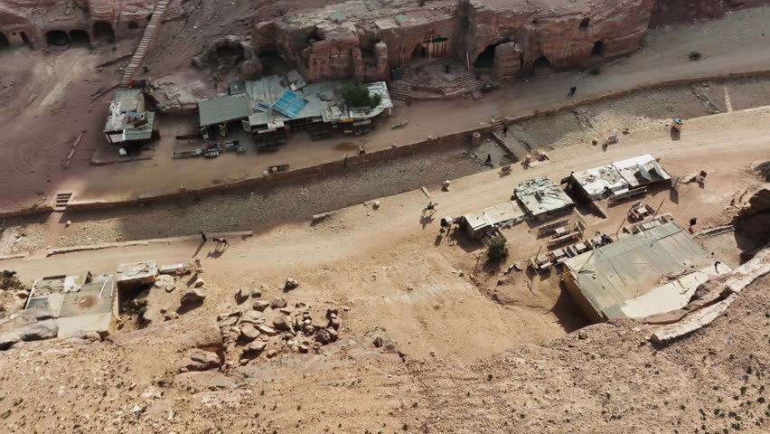 Drone shot following a person riding through a ancient city ruins in Wadi rum, Jordan