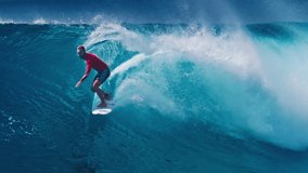 Surf cinemagraph. Young man in red shirt surfs the wave. Seamlessly loopable clip of the surfer riding the wave