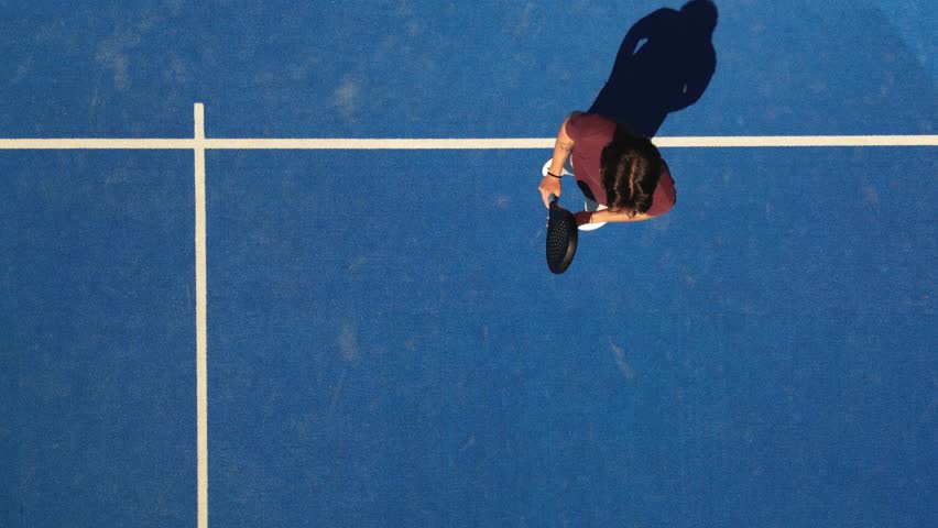 Overhead top view shots of a young padel player hitting the ball with a smash bandeja vibora on the fly.
 Royalty-Free Stock Footage #1103639587