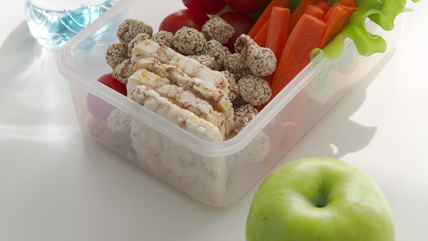 Food in a lunch box on the table top view close-up. A balanced healthy snack for a lunch break at school, college, at work in the office. Back to school concept.