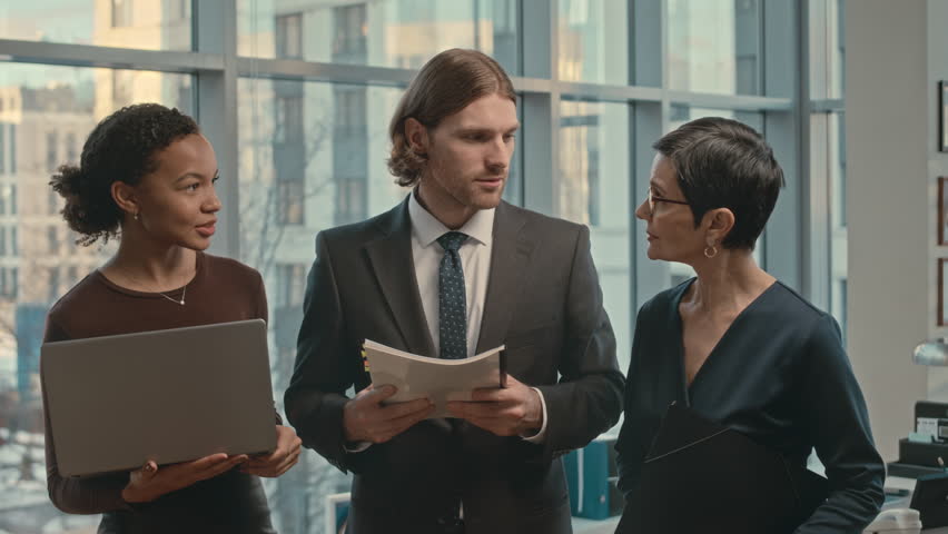 Medium portrait of young professional diverse lawyers team talking in luxury office then looking at camera | Shutterstock HD Video #1103646561