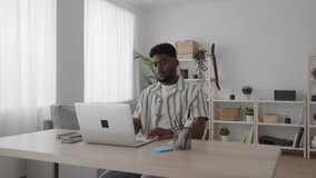 Black young man having video call and working at home on laptop. African American person talking online.