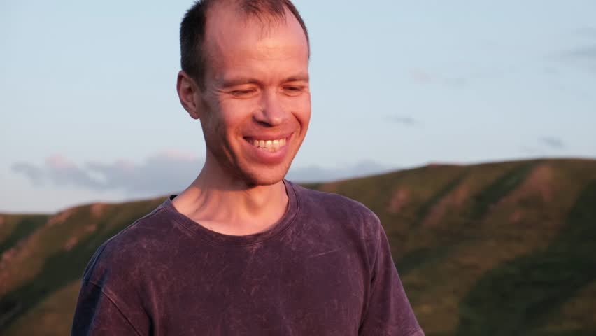 forty-year-old man walking at sunset smiling at the camera